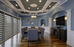 A formal dining room with a decorative ceiling and hardwood floors.
