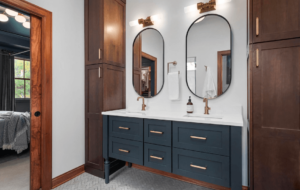 A bathroom vanity with dual sinks and large, oval mirrors.