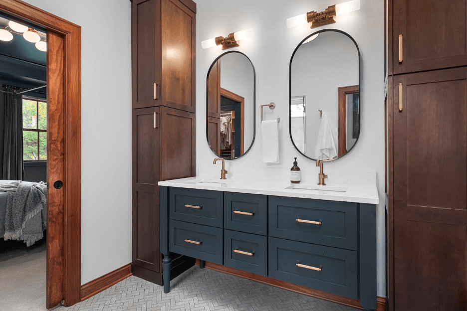 A bathroom vanity with dual sinks and large, oval mirrors.