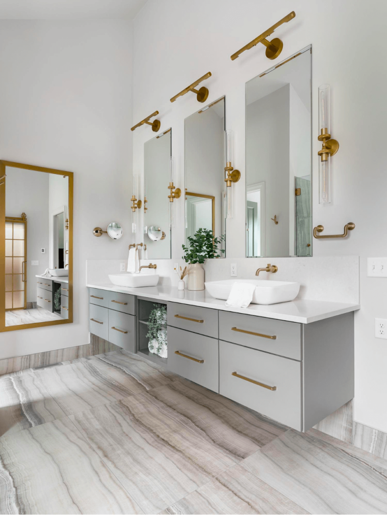 A floating bathroom vanity with matte gold fixtures and three rectangular mirrors.