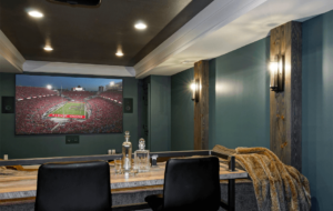 A recently remodeled basement with a media room, large television, and luxurious seating.